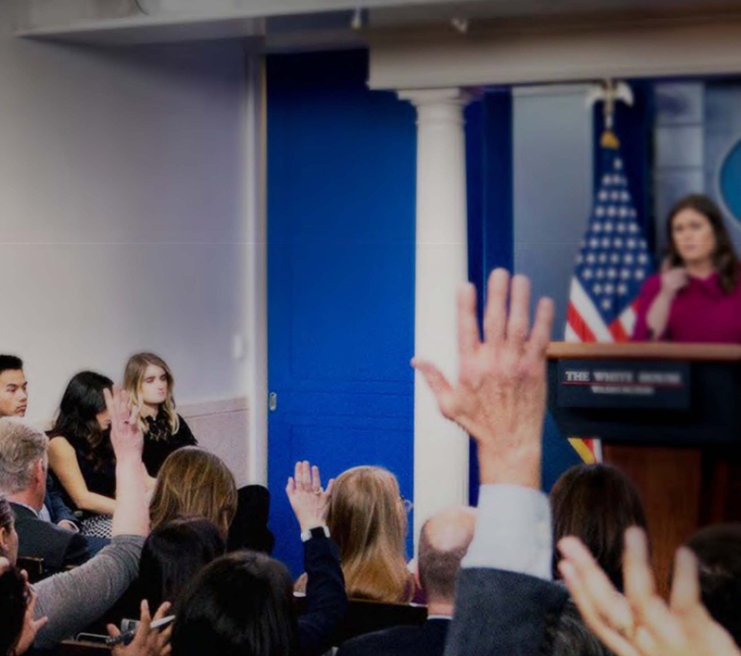 Reporters raise hands in the White House press room.